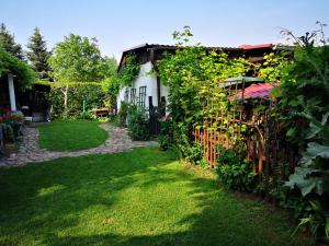 a garden with a white house and a fence at Sielankowy Domek in Ośno Lubuskie