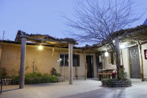 uma casa com um pátio com uma árvore em frente em hostal iquisa em San Pedro de Atacama