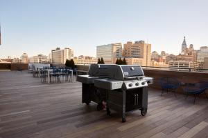 a grill on a rooftop with a view of a city at Sonder at Sixteen Hundred in Philadelphia