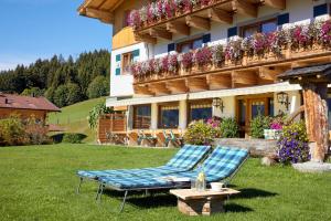 a couple of chairs on a lawn in front of a building at Hotel Gasthof Abelhof in Neukirchen am Großvenediger