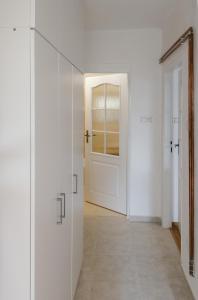 einen Flur mit weißer Tür und Fliesenboden in der Unterkunft Apartmán v Sedlici in Sedlice