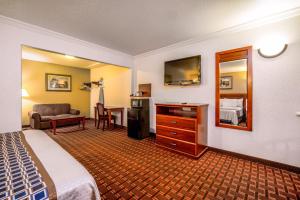 a hotel room with a bed and a mirror at Regency Inn & Suites Downey in Downey