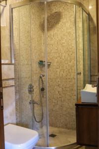 y baño con ducha, aseo y lavamanos. en Doruk Hotel, en Ayvalık