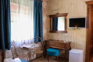 a room with a desk and a table and a television at Doruk Hotel in Ayvalık