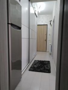 pasillo con cocina con nevera y alfombra en Apartament Luk Twin Loft, en Mamaia