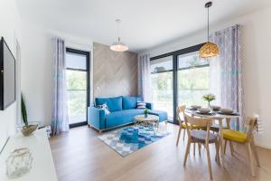 een woonkamer met een blauwe bank en een tafel bij Helskie Tarasy in Hel