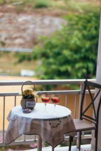 two glasses of wine on a table on a balcony at Roxanne’s Home in Limenas