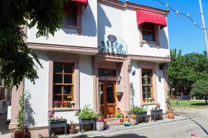 a white house with flowers in front of it at Doruk Hotel in Ayvalık