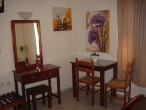 y baño con mesa, sillas y espejo. en Iliaktida Apartments en Kolymvari