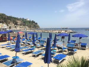 a bunch of chairs and umbrellas on a beach at LA CASETTA DI ERIKA in Lacco Ameno