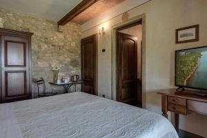 Un dormitorio con una cama y un televisor de pantalla plana. en Villa Del Sole, en San Gimignano
