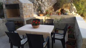 einen Tisch und Stühle mit einem Blumentopf auf einer Terrasse in der Unterkunft Apartman Zaklopatica in Lastovo