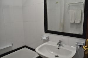 
a bathroom with a sink, mirror and bath tub at Hotel Casa Portuguesa in Meaño
