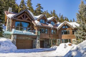a log home in the snow at 3354 Peak Drive in Whistler