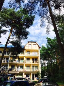 a tall building with cars parked in front of it at Apartamenty Platinum 2 in Łukęcin