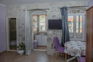 un soggiorno con sedia viola e TV di Devivi Apartments a Spalato (Split)