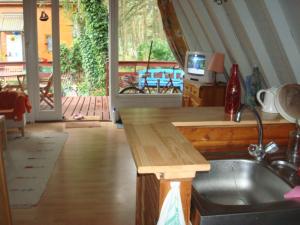 une cuisine avec un comptoir et un évier ainsi qu'une terrasse couverte dans l'établissement Domek letniskowy Pirat, à Mrzeżyno