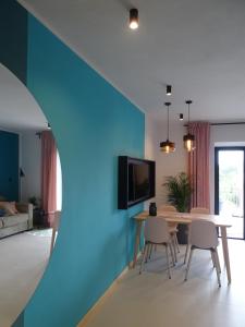 salon ze stołem i niebieską ścianą w obiekcie Apartments Pržina w mieście Lumbarda