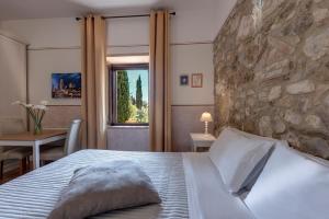Un dormitorio con una cama y una pared de piedra. en Villa Del Sole, en San Gimignano 102 fotos más