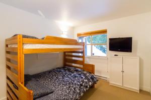 a bedroom with two bunk beds and a television at Ski in Out, Great Location, Free Shuttle Bus in Whistler