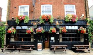 a pub with benches in front of a building at Prince Arthur in London