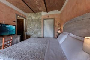 
a hotel room with a bed and a tv at Villa Del Sole in San Gimignano
