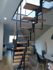 a wooden spiral staircase in a room with chairs at Apartamenty Platinum in Łukęcin