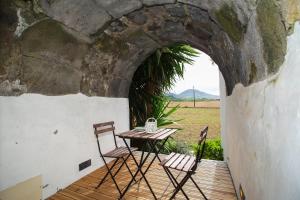 une table et deux chaises sur une terrasse en bois dans l'établissement Casa do Pico Arde, à Ribeira Grande