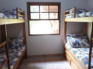 een kamer met 2 stapelbedden en een raam bij Casa de campo in Petrópolis