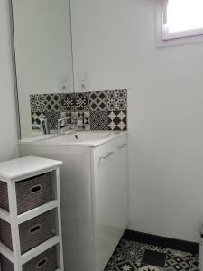 a white bathroom with a sink and a mirror at Gîte les Oliviers les HERBIERS in Les Herbiers
