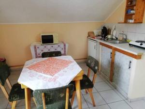 a small kitchen with a table with a table cloth on it at Tuja Vendégház in Lajoskomárom +6 photos