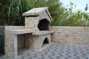 a stone outdoor oven with a sink on a patio at Villa Antea - modern house with pool in Pag