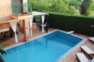 a large swimming pool with a patio and a house at 4-seasons pool villa near Meteora in Tríkala