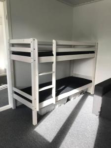 リーベにあるBB-Vadehavet Ferielejlighed til 6 personer ved Nationalpark Vadehavetの白い二段ベッドが備わる客室です。