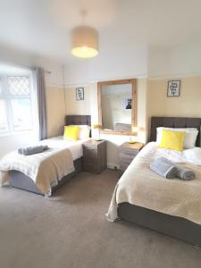 a bedroom with two beds and a large window at Off Road parking, Garden, TV in Every Room in Swansea