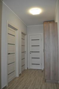 een lege kamer met twee witte deuren en houten vloeren bij Apartments on Leva st. in Berehove