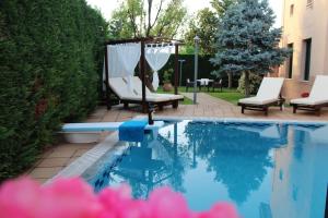 einen Pool mit zwei Stühlen und einem Pavillon in der Unterkunft 4-seasons pool villa near Meteora in Tríkala