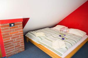 - un lit dans une chambre à côté d'un mur en briques dans l'établissement Apartment Nani, à Jesenice