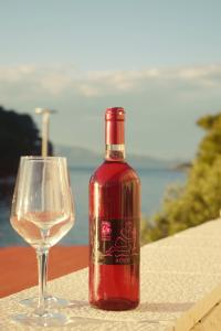 a bottle of wine next to a wine glass at Mljet Sunset Apartments in Pomena