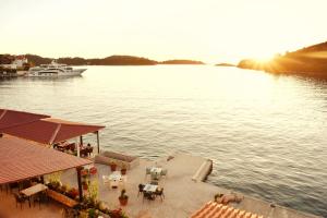 a boat is docked on a river with a dock at Mljet Sunset Apartments in Pomena