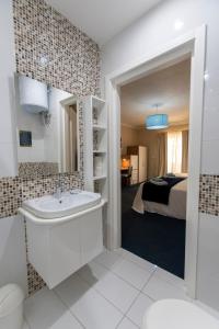 a bathroom with a sink and a bedroom at Estrella Lodging in Rabat