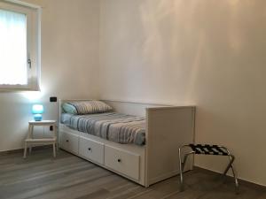 a small bedroom with a bed and a chair at Appartamento tra lago e cielo in Como
