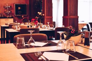 une table dans un restaurant avec des verres et des serviettes dans l'établissement Hotel Vienna, à Marghera