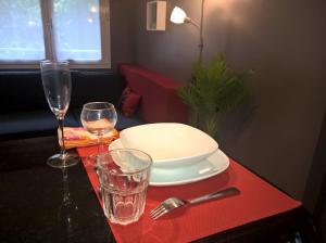 a table with a plate and two glasses on a table at Charmant F2 Paris Expo Versailles in Vanves