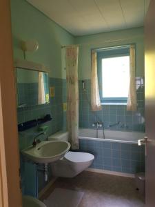 ein Badezimmer mit einem Waschbecken, einem WC und einer Badewanne in der Unterkunft Casa La Berika in Orselina