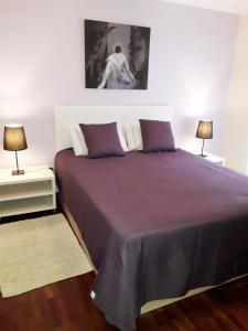 a bedroom with a large bed with two lamps at Apartamento Capela in Funchal