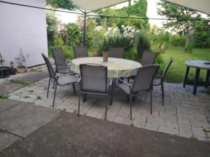 um pátio com uma mesa e cadeiras num quintal em Apartman Lux em Szeged