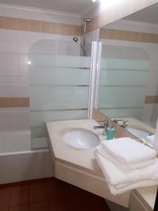 y baño con lavabo, espejo y bañera. en Apartamento Capela, en Funchal