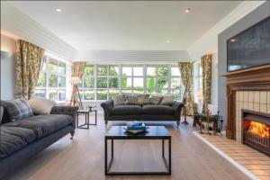 a living room with two couches and a fireplace at Denbrae Cottage West in St. Andrews