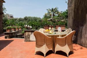 a patio with a table and chairs on a patio at Villa Zagara - La Serra in Sorrento